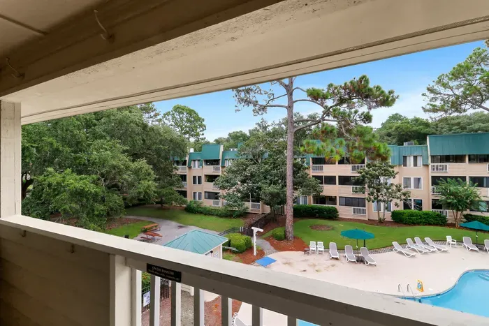 Private covered balcony with pool views and peaceful courtyard scenery
