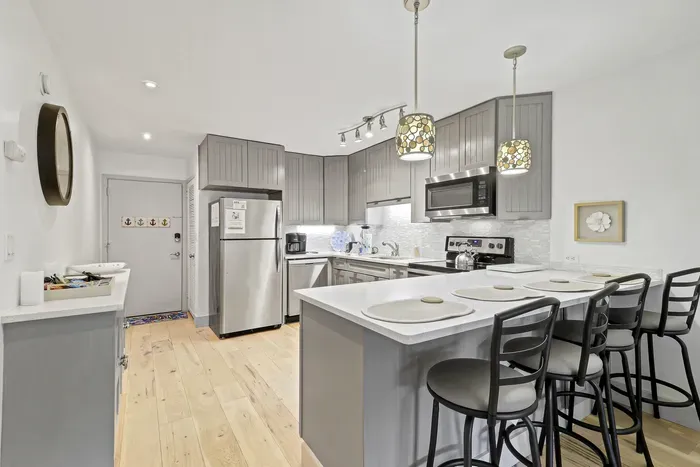 Bright modern kitchen with island seating for 4 and stainless appliances