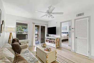 Bright cozy living room with TV, natural light, and private balcony access