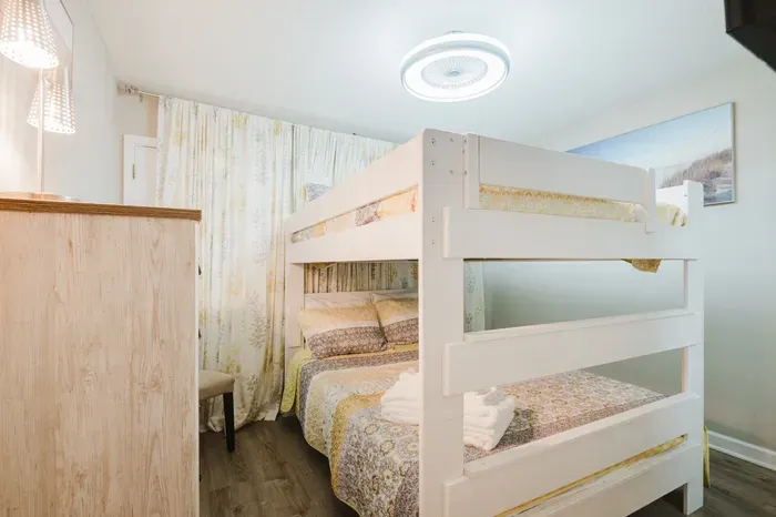 Queen-over-queen bunk, not twins. Sleeps four adults comfortably, so nobody's negotiating for the couch.