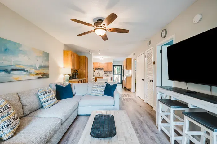 Smart TV, sectional that sleeps a straggler, and a coffee table built for takeout containers. Beach day ends here.