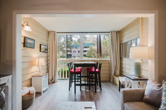 The room that sells the villa. Wraparound windows, lagoon and live oaks out front, and it's still connected to the living room.
