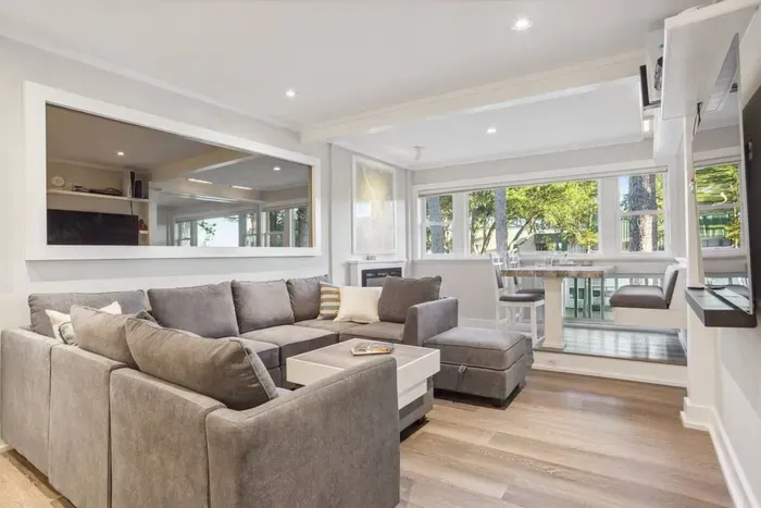 Abundant natural light streams through large windows in the living room