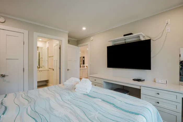 Bright bedroom with TV, built-in desk, and easy bathroom access