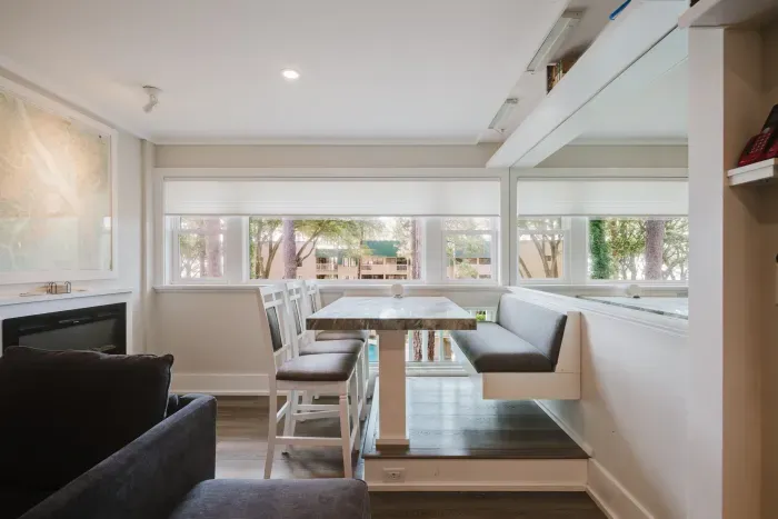 Bright window-side dining nook with banquette seating and peaceful tree views