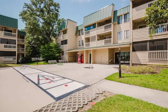 Relaxing courtyard with shuffleboard, cornhole, and private balconies