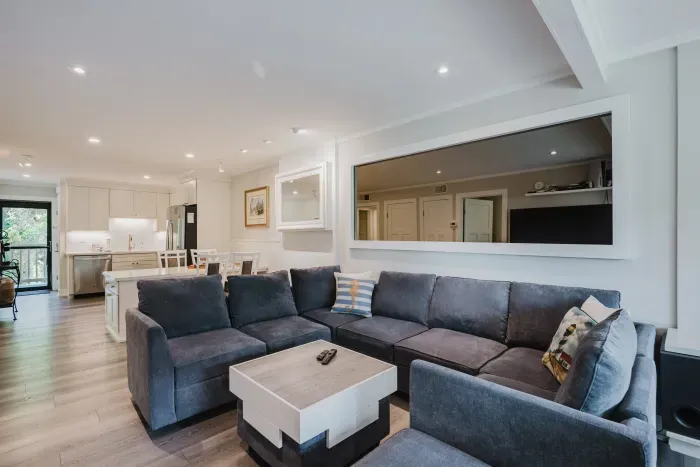 Bright open-concept living room with large sectional and modern kitchen