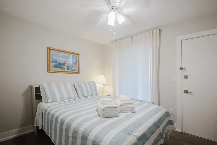 Bright, cozy bedroom with soft linens, fresh towels, and a relaxing feel