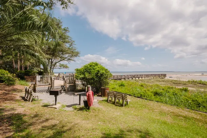 Beachfront lawn with grill, shaded seating, and direct boardwalk access
