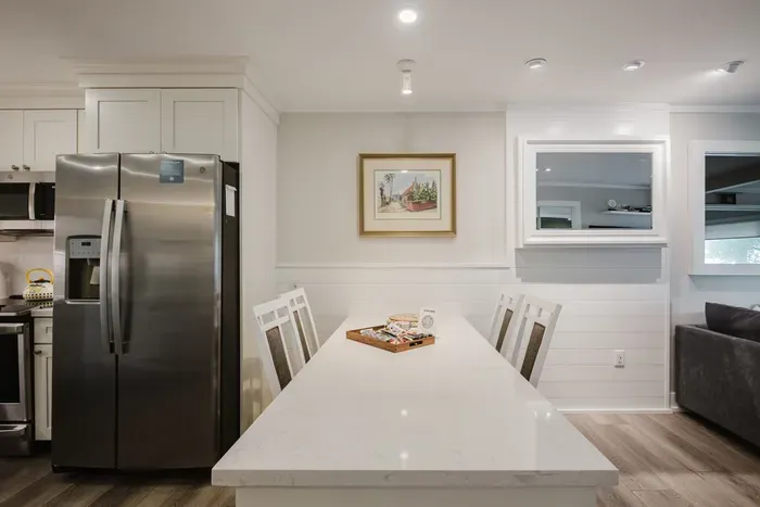 Bright modern dining area with large table beside the fully equipped kitchen