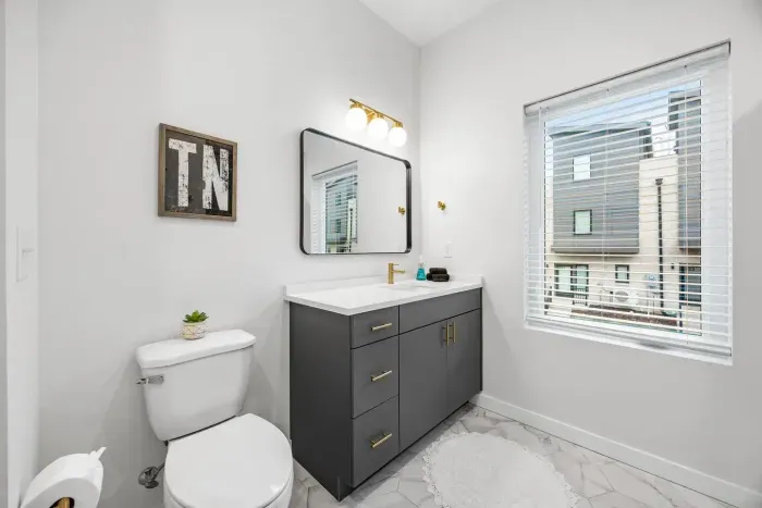 The full bathroom connected to the primary suite is complete with modern finishes and a tile shower.