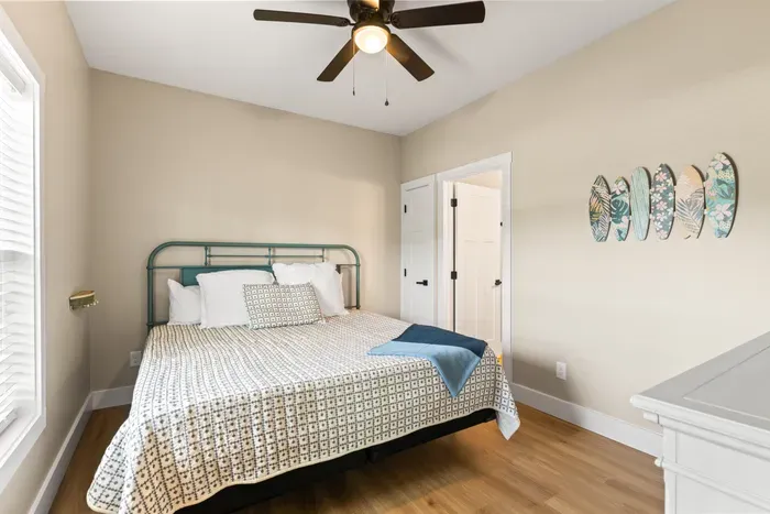 Queen bed with a vintage iron frame, a private bath through the door, and a window that catches afternoon light.