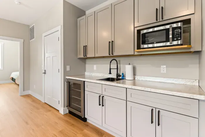 Beverage fridge, microwave, and a sink downstairs. Snacks and drinks without a trip up to the main kitchen.