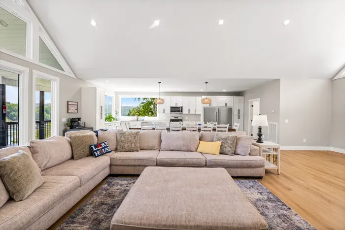 Sectional, dining table, and kitchen all in one open room. Deck doors right there for lake day traffic in and out.