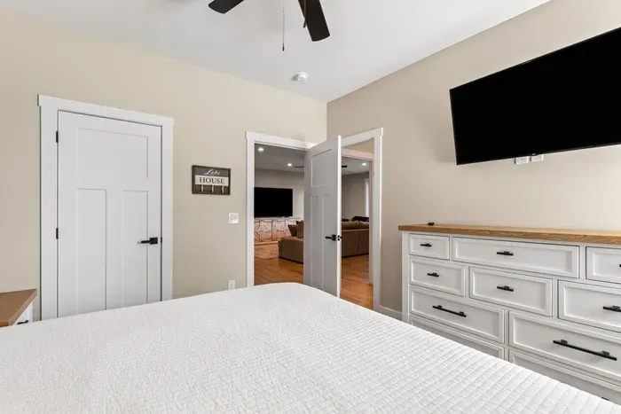 King bed, big dresser, and a mounted TV, with the lower-level den right outside the door.