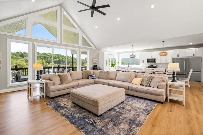 Vaulted ceilings, a wall of windows, and a sectional the whole group can pile onto. Open to the kitchen and dining, so nobody's stuck cooking alone.