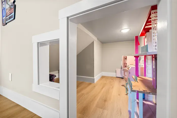 A tucked-away play space with a dollhouse and a peek-through window. The little ones will find this before you finish unloading.