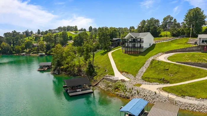Door to dock in under a minute. Concrete path runs straight from the house to the water — a short walk with a grade to it. Plan for a couple of trips with coolers, or take your time