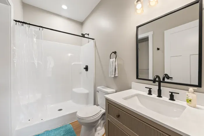 Walk-in shower, quartz vanity, and closet storage. One of six full baths in the house.