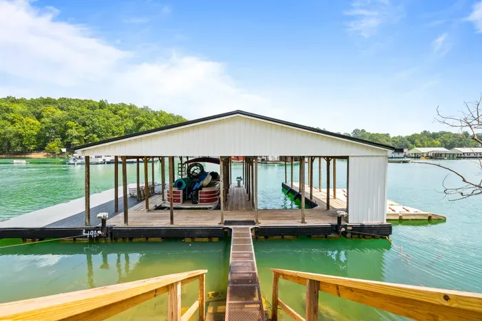 Covered slip with a ramp down from shore, plus an open deck section for towels and coolers. Room to tie up and swim off the end.