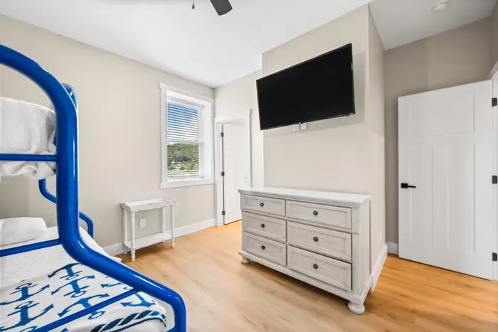 Wall-mounted TV and a full dresser in the bunk room. Room for the cousins to spread out their stuff.