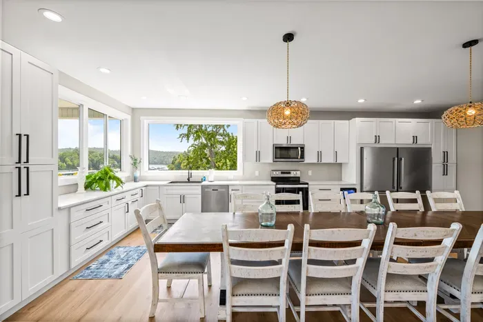 Quartz counters, full-size range, and a dining table that seats a dozen. Windows over the sink so the cook still gets the view.