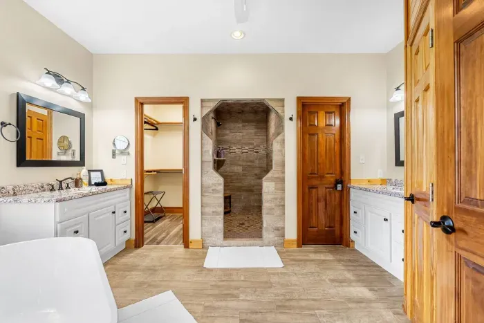 Welcome to the master bathroom with his and her vanities, large soaking tub, and walk in shower.
