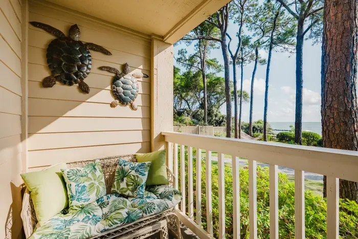 A cushioned settee on the shaded balcony — the spot for morning coffee before anyone else is awake.