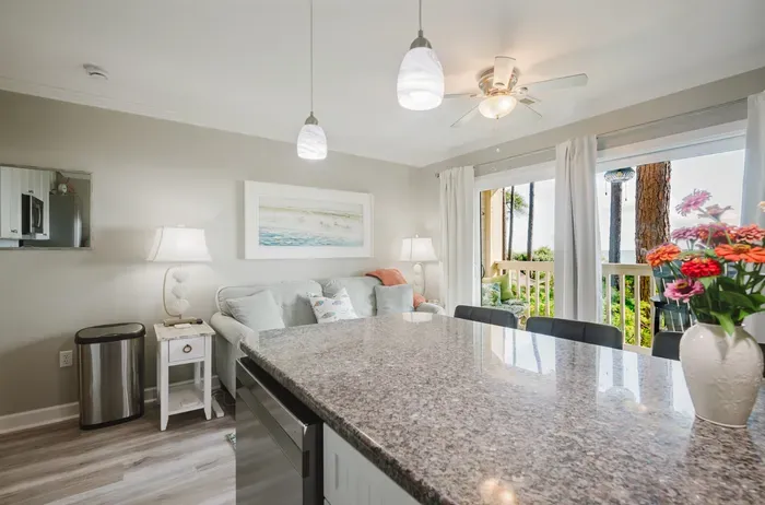 Granite breakfast bar seats three, with the living room and Sound-facing balcony just beyond. Cook, pour a glass of wine, and never lose the view.