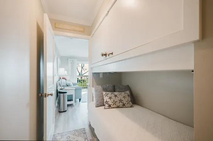 A built-in hallway bunk adds a fourth sleeping spot without giving up the sofa. Tucked into its own alcove just off the living room.