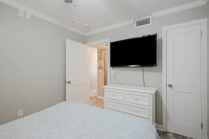 Smart TV, a full dresser for unpacking, and a closet for hanging. The hallway just outside leads to the bath, laundry, and living room.