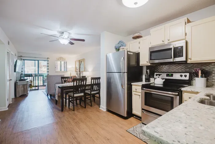 Bright open kitchen, dining area, and balcony access