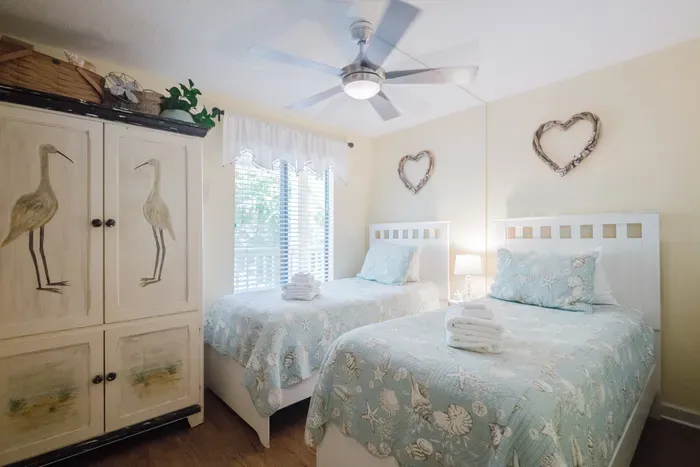 Bright coastal twin bedroom with natural light and charming beach decor