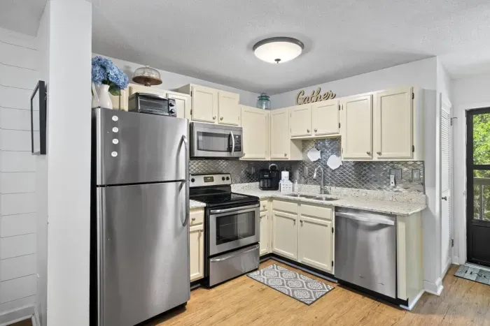 Off-white cabinetry and granite countertops complete the kitchen's design