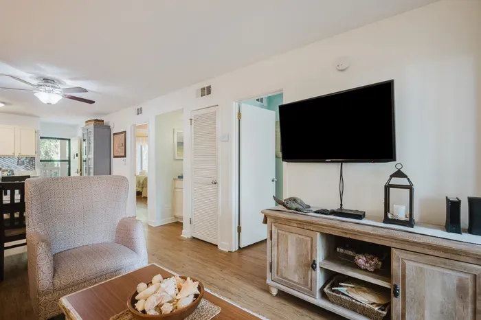 Bright open living space with large TV and inviting coastal charm
