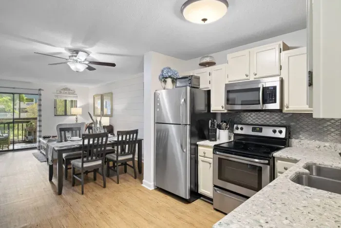 The kitchen features stainless steel appliances, including a refrigerator, microwave, and stove.