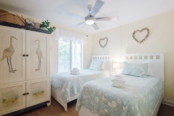 Bright coastal twin bedroom with charming décor and sunny window