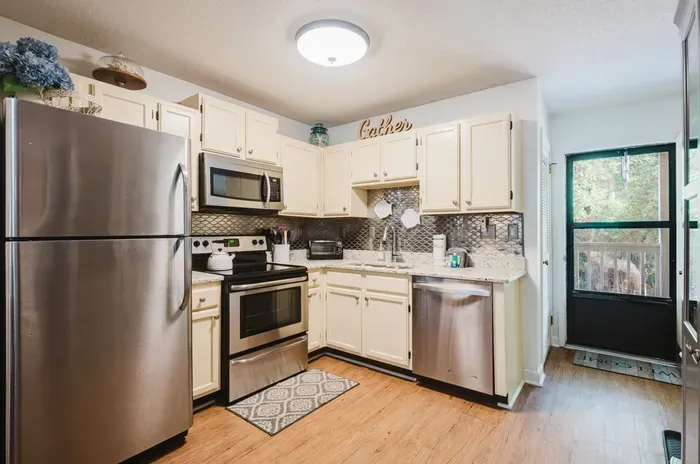 Bright updated kitchen with stainless appliances and stylish backsplash