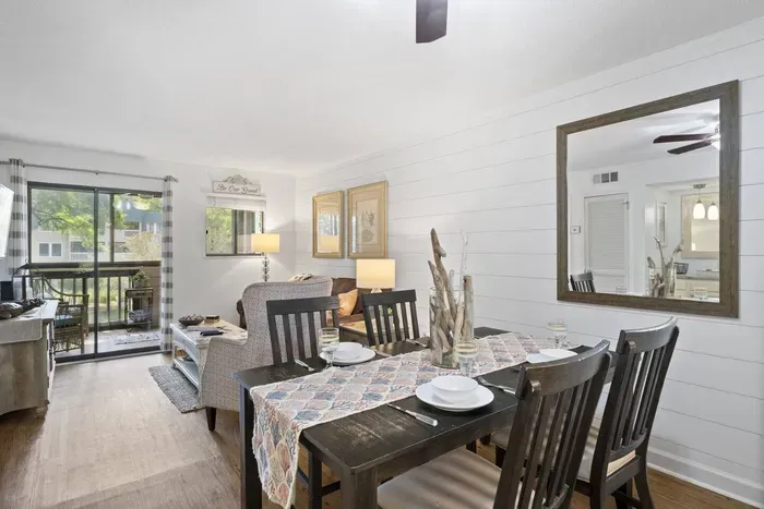 A dining area with a dark-brown wooden table and ship lap lined wall.