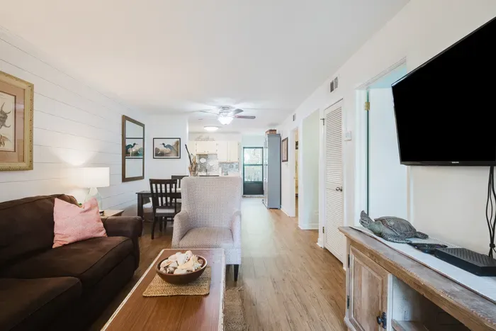 Bright coastal living space with open layout, dining nook, and TV
