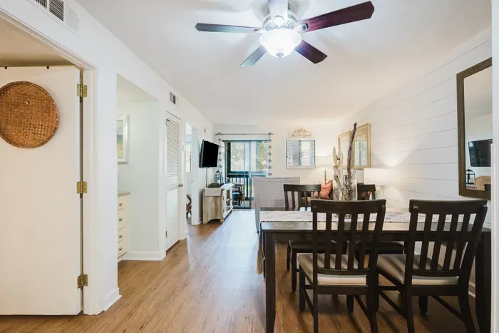 Bright open dining & living space with balcony access and coastal charm