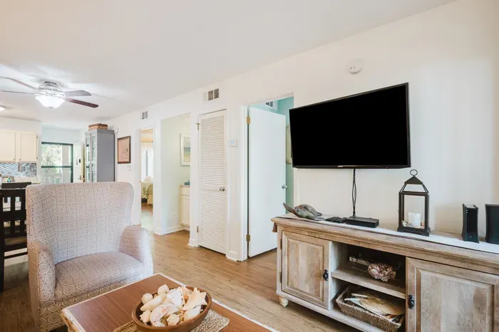 Bright open living room with large TV and easy flow to dining area