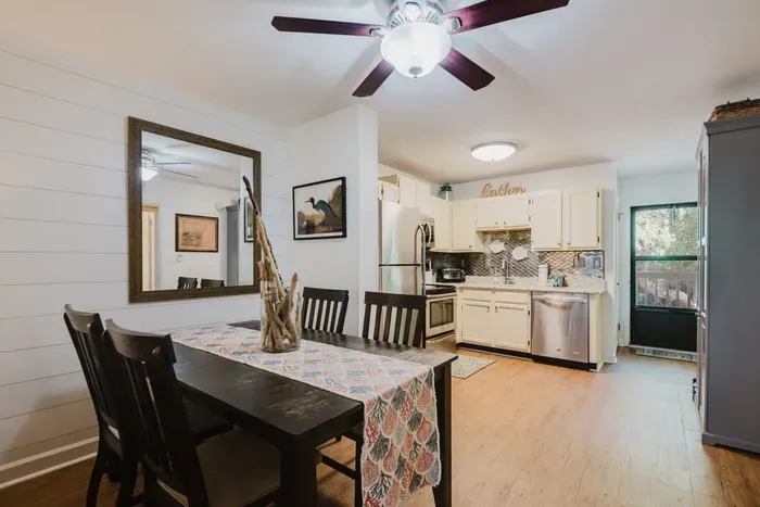 Bright open dining and kitchen space with seating for four and outdoor access
