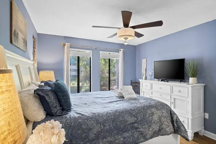 First bedroom with a light, periwinkle-blue painted wall and SMART TV.