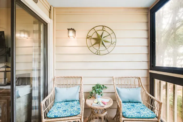 Cozy screened balcony with wicker seating and relaxing nature views
