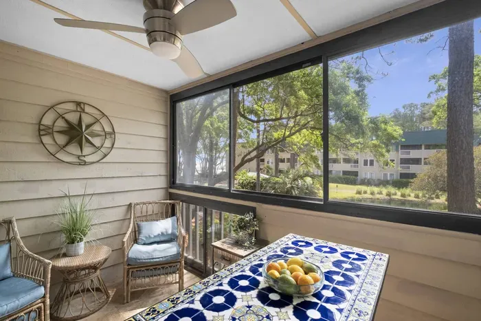 Beyond the glass sliding doors and walls, a view of lush green trees