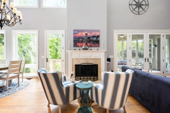 Two stories of windows, cathedral ceilings, and French doors that open straight onto the screened porch. The fireplace is decorative only.