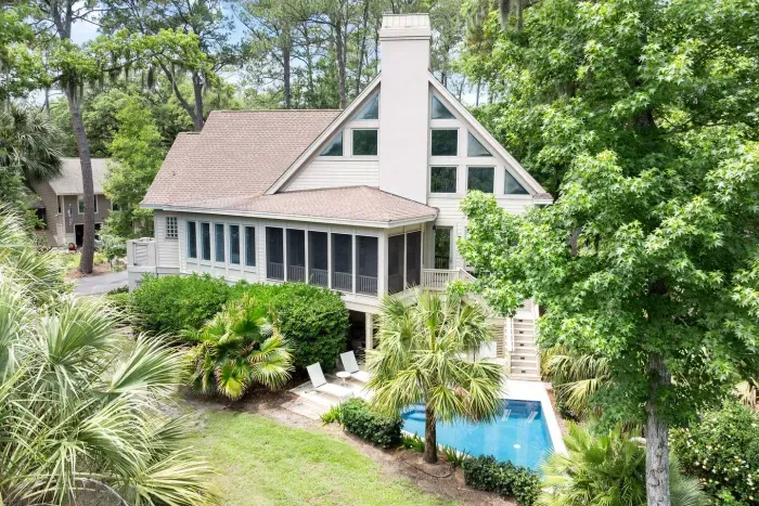 The house from above: screened porch, pool deck, and lawn running out to the lagoon.