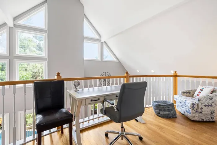 Loft workspace overlooking the great room. Desk, chairs, and light from three sides.