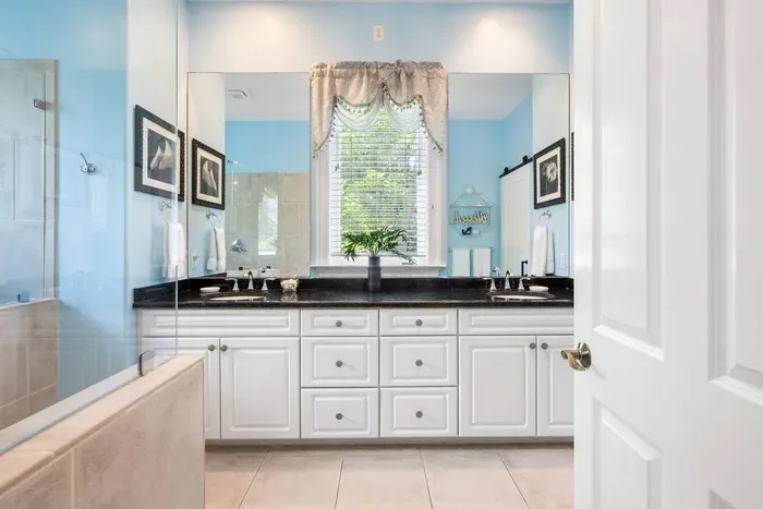 Primary bath with double granite vanities and a soaking tub beside the walk-in shower.
